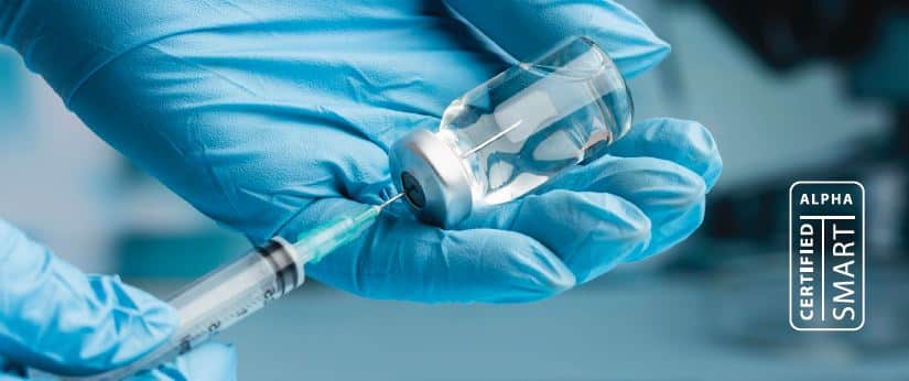 Gloved hand handling medical vials